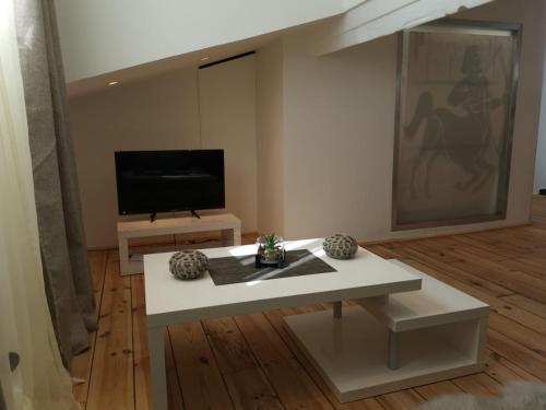 a living room with a white table and a tv at Le Croisette center in Cannes