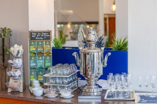Un trofeo de plata sobre una mesa con vasos. en Carat Hotel Grömitz, en Grömitz