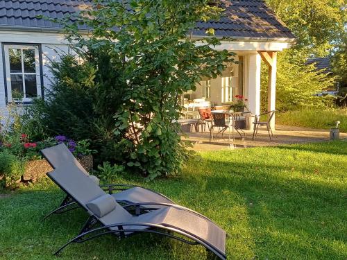 a chair sitting in the grass in front of a house at B&B Het mooie uitzicht in Reuver