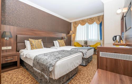 una camera d'albergo con due letti e una televisione di Ma City Hotel a Istanbul