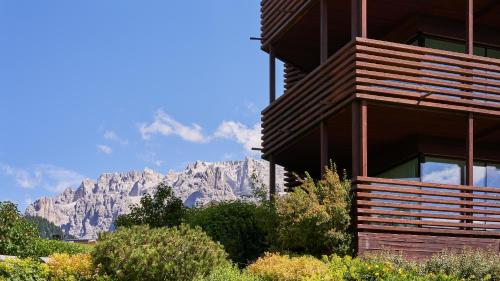 ein Gebäude mit einem Berg im Hintergrund in der Unterkunft Saleghes Dolomites Residence in Wolkenstein in Gröden