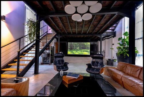 a living room with a couch and a table at La Chapelle du Carmel - Centre ville - 340 M2 - SPA - Cinéma - Parking - in Reims