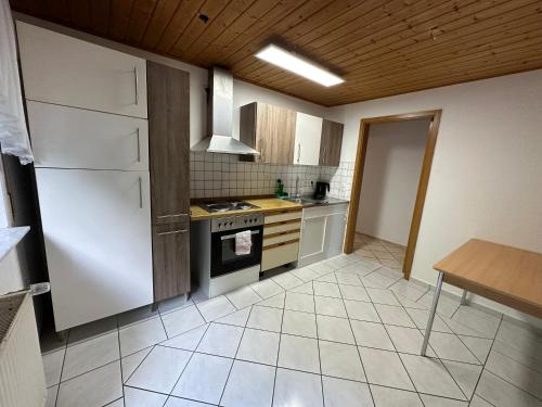 a kitchen with white appliances and a wooden ceiling at HW1 Drei Zimmer Wohung 80qm in Königsbronn