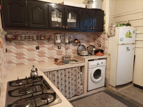 a kitchen with a stove top oven next to a refrigerator at Ain sbaa Hay mohmmadi in Casablanca