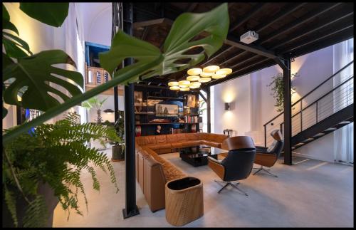 a living room with a couch and some plants at La Chapelle du Carmel - Centre ville - 340 M2 - SPA - Cinéma - Parking - in Reims