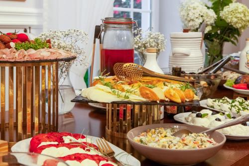a buffet of food on a table with plates of food at Małopolanka & Spa in Krynica Zdrój