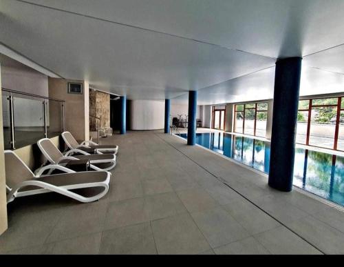 施柯拉爾斯卡波倫巴的住宿－Apartament Michaś，大楼内带椅子和游泳池的走廊