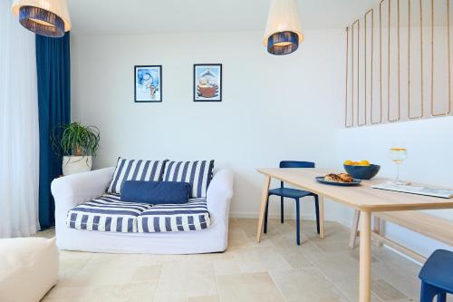 ein Wohnzimmer mit einem weißen Stuhl und einem Holztisch in der Unterkunft Hedera Estate Hedera Studio 1 in Dubrovnik