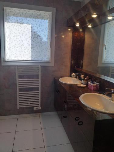 a bathroom with two sinks and a large window at Fan 36B in La Roche-de-Glun