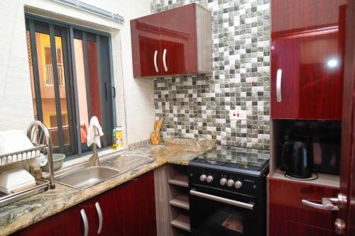 a kitchen with a sink and a stove top oven at GOD'S TOUCH APARTMENTS SHORT-LET Adenugba Street Oregun Ikeja Lagos Nigeria in Ikeja