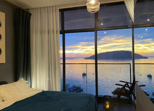 Dormitorio con ventana grande con vistas al agua en Seaview Bliss Studio By Tropical Elegance, en Kota Kinabalu