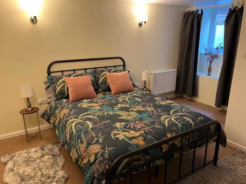 a bedroom with a bed with pillows and a window at The Annex in Ottery Saint Mary