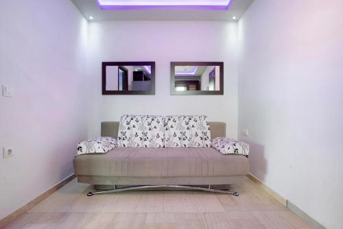 a couch sitting in a room with two mirrors at Villa Dionysia Apartment A2 in Alikanas