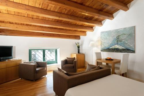 a living room with wooden ceilings and a couch and chairs at Hotel Palazzo Brunaccini in Palermo