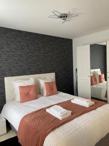 a bedroom with a large bed with orange and white pillows at Le Cubry : Appart hyper-centre avec une place de parking in Épernay
