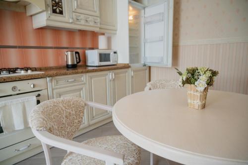kuchnia ze stołem, krzesłami i kuchenką mikrofalową w obiekcie One bedroom apartment with balcony-Kostyushka street,16 w Lwowie