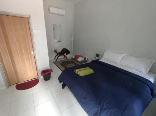um quarto com uma cama azul com uma almofada amarela em Cahaya roomstay em Kangar