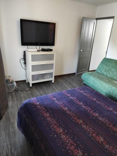 1 dormitorio con cama y vestidor con TV en Appart Cosy Henin Centre, en Hénin-Beaumont