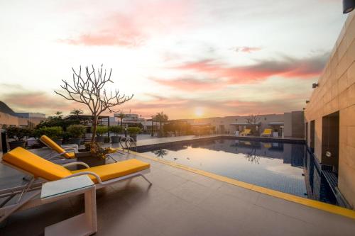 海得拉巴的住宿－Marigold Hotel，一座游泳池,里面设有黄色的躺椅