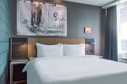 a bedroom with a white bed and a painting on the wall at Radisson Blu Hotel Bodø in Bodø