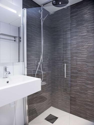 a bathroom with a sink and a glass shower at Radisson Blu Hotel Bodø in Bodø