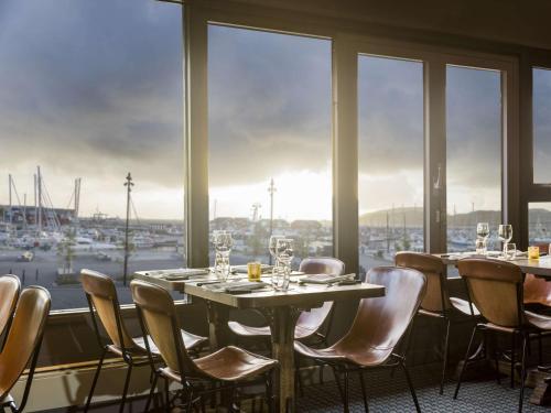 a dining room with tables and chairs and a large window at Radisson Blu Hotel Bodø in Bodø