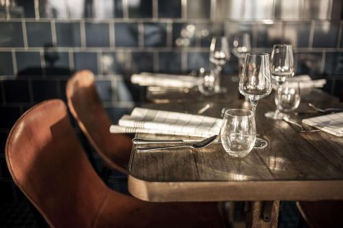 a wooden table in a restaurant with wine glasses at Radisson Blu Hotel Bodø in Bodø