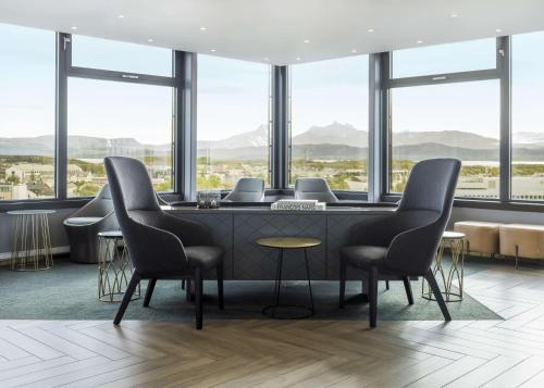a waiting room with chairs and a table and windows at Radisson Blu Hotel Bodø in Bodø