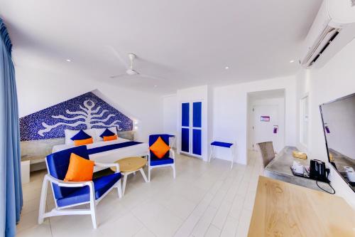 a room with a bed with blue and orange pillows at Trinco Blu by Cinnamon in Trincomalee