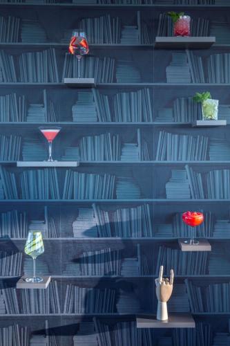 a blue wall with shelves with glasses and vases at Radisson Blu Hotel Bodø in Bodø
