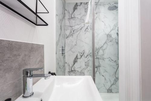 a bathroom with a sink and a shower at St Meddans Mews - Donnini Apartments in Troon