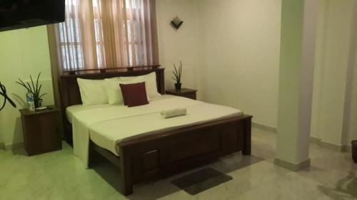 a bedroom with a large bed with white sheets at Enara Luxury Stay in Katugastota