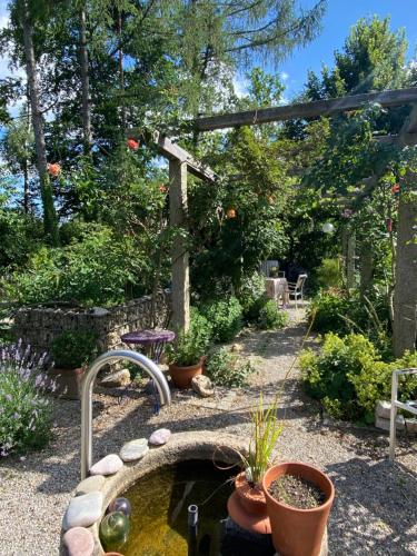 a garden with a pond and a pergola at Ferienwohnung Jardin im Kunsthaus in Greifenberg