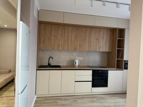 uma cozinha com armários brancos e um lavatório em Loft Aparts em Chisinau