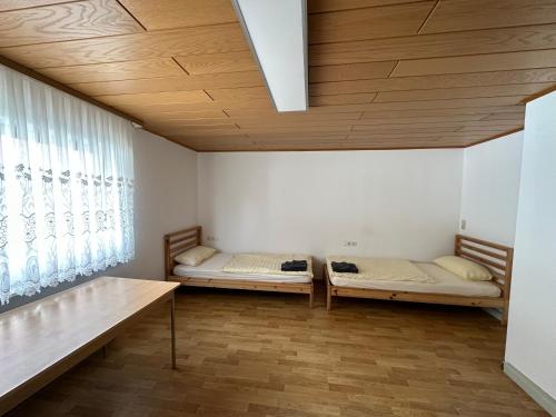 two beds in a room with a wooden ceiling at HW1 Drei Zimmer Wohung 80qm in Königsbronn