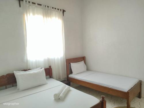 a room with two beds and a window at Manama Suites Apartment in Lamu