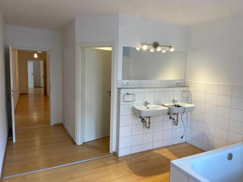 a bathroom with two sinks and a mirror at BnB-Home Apartment in Buxheim