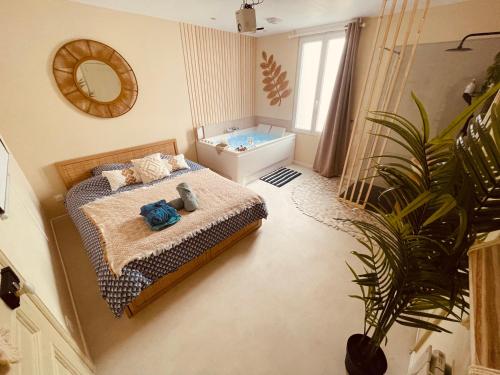 - une chambre avec un lit et une plante en pot dans l'établissement L'appartement un cocon d'amour - studio balnéo - 208, à Le Petit-Quevilly