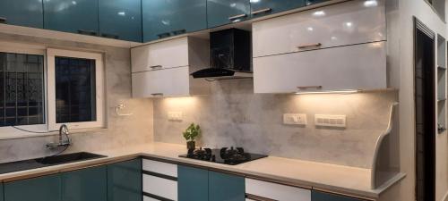 a kitchen with white cabinets and a sink at The Candy Studio in Rānchī