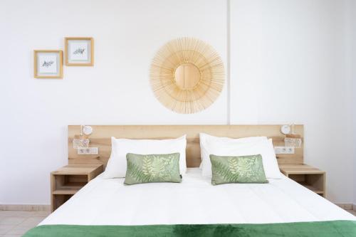 a bedroom with a large white bed with green pillows at Home2Book Stylish Apt Amarilla Golf, Pool&Terrace in San Miguel de Abona