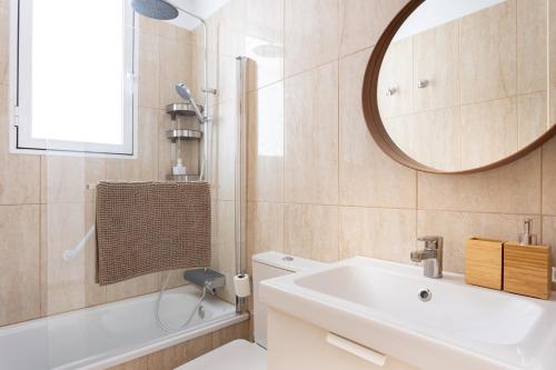 a bathroom with a tub and a sink and a mirror at Home2Book Stylish Apt Amarilla Golf, Pool&Terrace in San Miguel de Abona