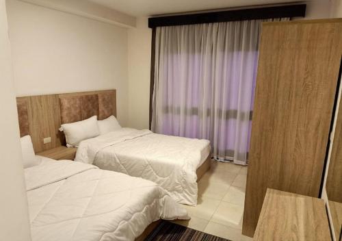 Tempat tidur dalam kamar di Spacious 2Bdrs duplex in Porto new Cairo