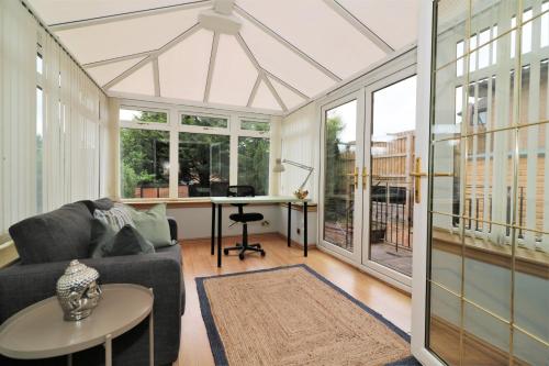 Signature - Binnie House في كومبيرنولد: غرفة معيشة مفتوحة مع أريكة ومكتب