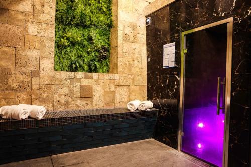Baño con toallas en una encimera con luz púrpura en Hazlewood Castle & Spa en Tadcaster