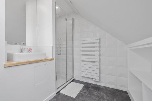 a white bathroom with a sink and a shower at la Villa du Thar - plage 300m piscine babyfoot arcade pingpong pétanque in Saint-Pair-sur-Mer