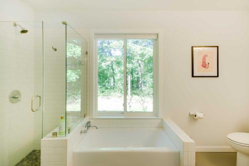 a white bathroom with a tub and a window at Quaint Charlottesville Home Less Than 10 Mi to Dtwn! in Earlysville