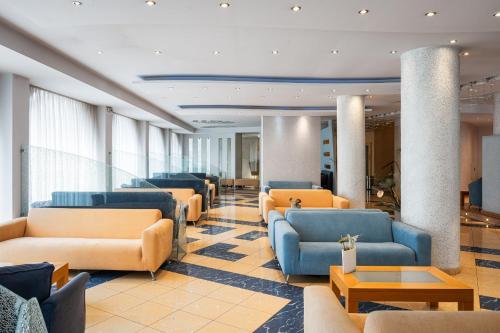 a waiting room with couches and chairs and tables at Kreoli Suites Glyfada in Athens
