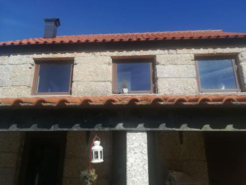 a building with three windows and a roof at Beiral da Marfida in Amarante