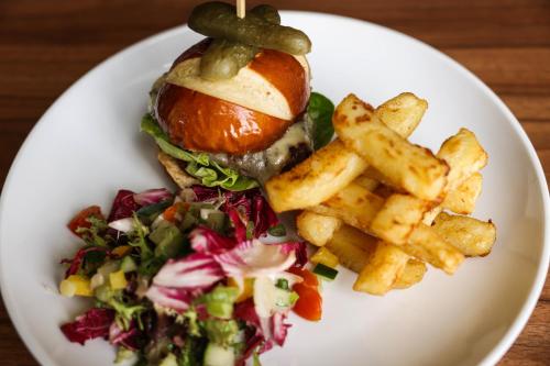 a white plate with a sandwich and french fries at Hazlewood Castle & Spa in Tadcaster