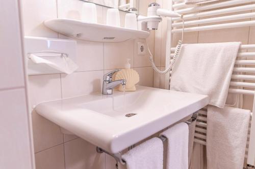 a bathroom with a white sink and towels at Hotel-Gasthaus Goldener Engel in Glottertal